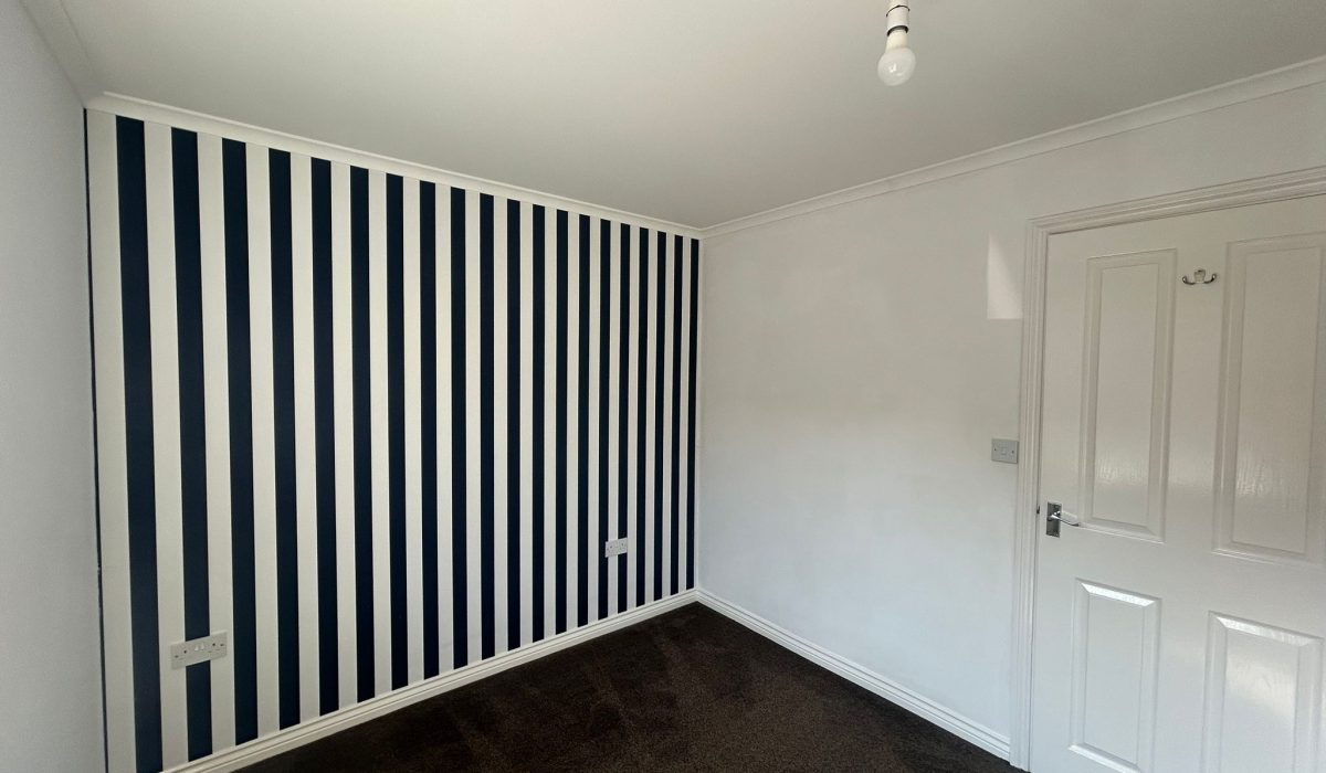 Double bedroom with striped feature wall in the Lundy Walk property