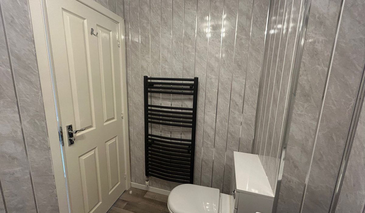 First-floor bathroom with toilet, vanity unit and heated towel rail