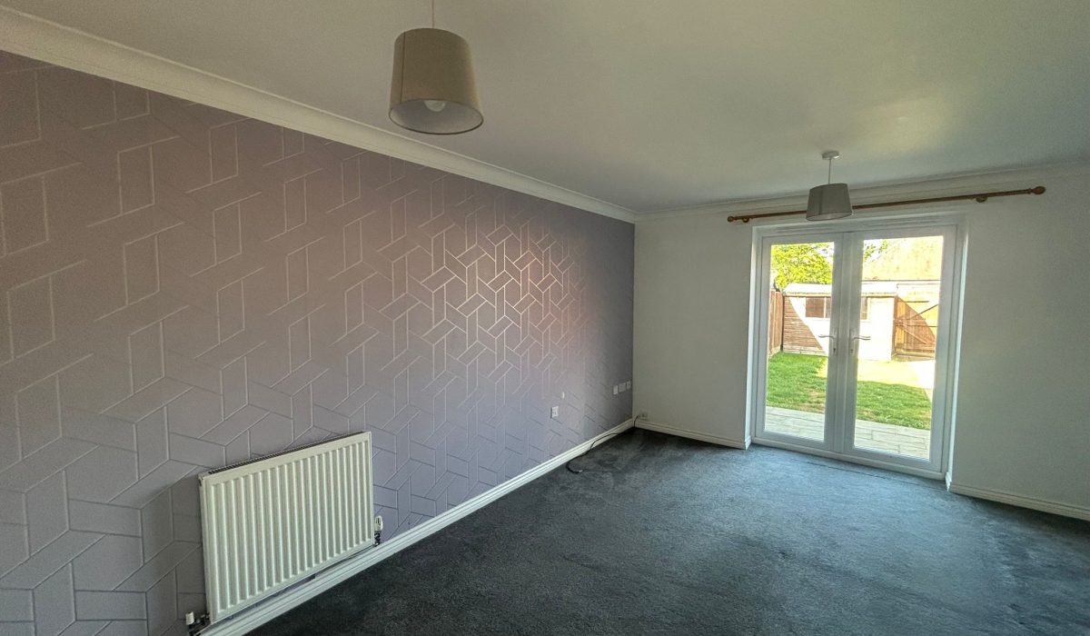 Lounge and dining area with feature wall and garden access